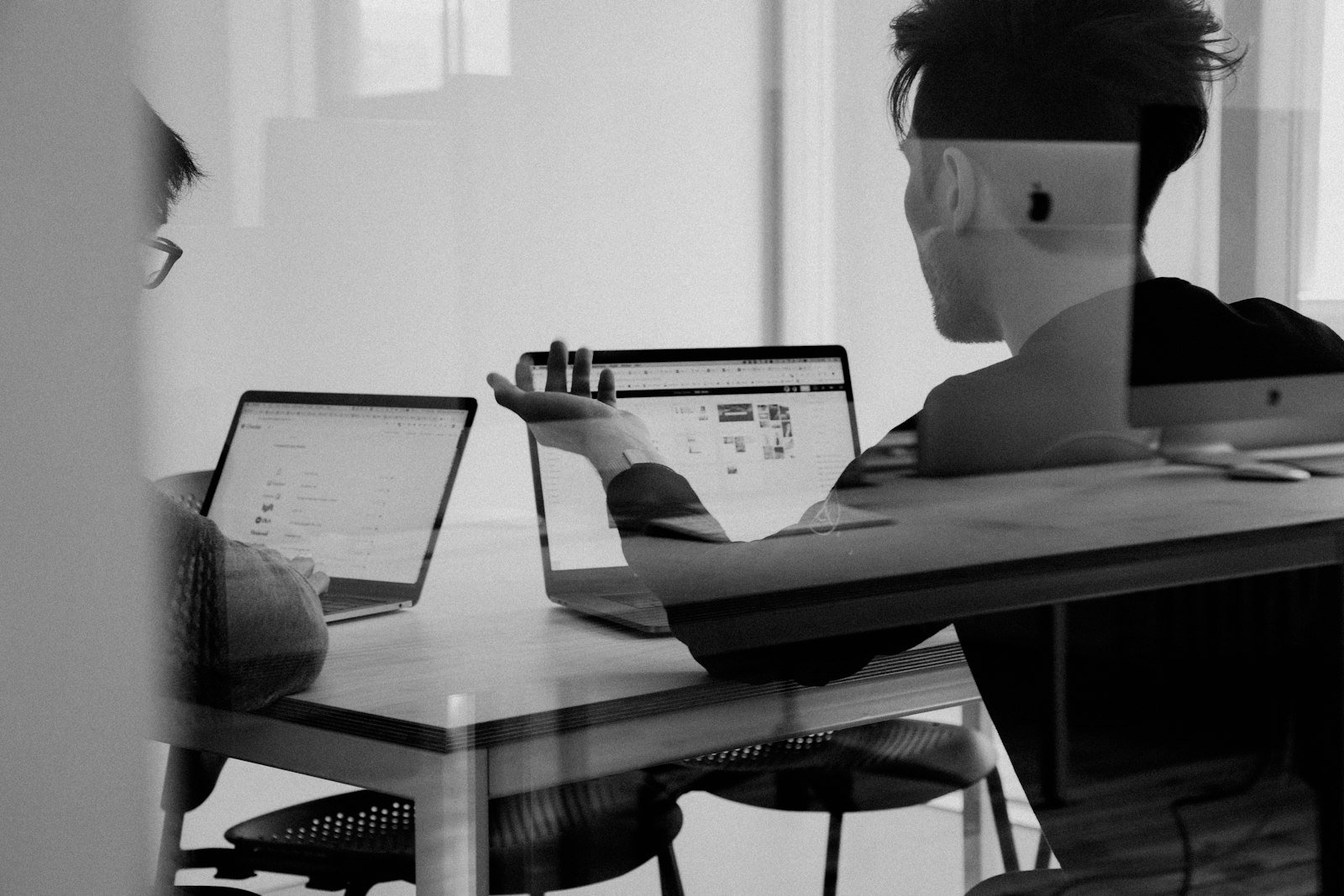 Product team comparing two AI app builder options on a whiteboard and laptop